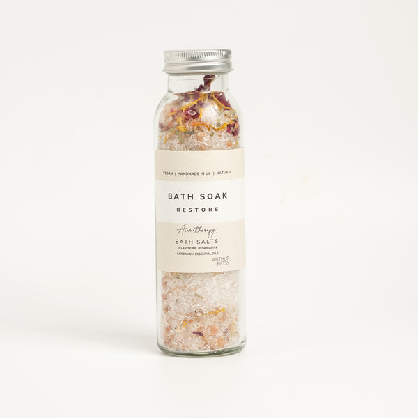 bath salt bottle containing bath soak with petals. wellbeing gifts