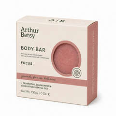 Arthur Betsy Focus Body Bar in a light beige box with a dusty pink circular window showing the bar inside, photographed on a clean white background. Arthur Betsy 100g handmade body soap with cedarwood, sandalwood and eucalyptus essential oils, hand-poured in Staffordshire.