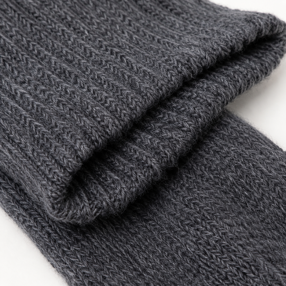A pair of dark charcoal gray ribbed wool socks with a white paper band label that reads 'Arthur Betsy WOOL SOCKS', shown on a clean white background. Arthur Betsy luxury alpaca wool socks in Twilight blue, made with an 80% alpaca wool blend for warmth, softness and everyday comfort.